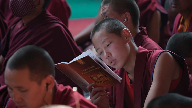 A young monk following the text during His Holiness the Dalai Lama's teachings preliminary to the Kalachakra Empowerment in Bodhgaya, Bihar, India on January 5, 2017. Photo/Tenzin Choejor/OHHDL
