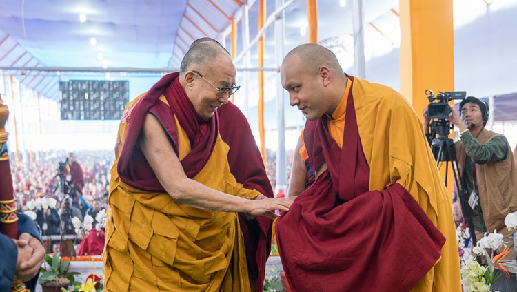His Holiness the Dalai Lama exchanging greetings with Gyalwang Karmapa as he arrives on stage for the second day of the Kalachakra Empowerment, Seven Empowerments in the Pattern of Childhood, in Bodhgaya, Bihar, India on January 12, 2017. Photo/Tenzin Choejor/OHHDL