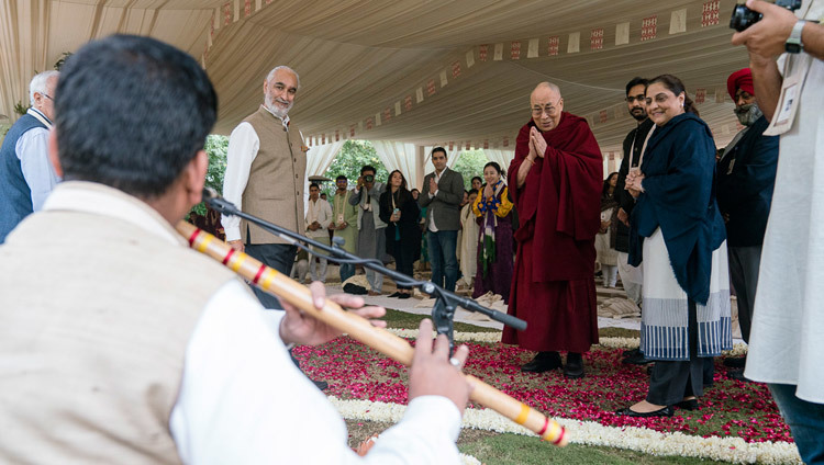 His Holiness the Dalai Lama taking a moment to listen to a flute player as he arrives at the start of the second day of the Vidyaloke teachings in New Delhi, India on February 4, 2017. Photo/Tenzin Choejor/OHHDL