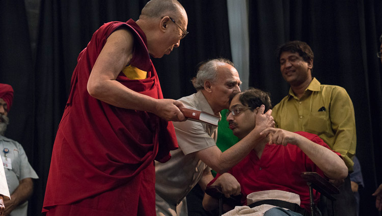 Arun Shourie embracing his son Aditya who had handed His Holiness the Dalai Lama a copy of "Two Saints" to mark the launch of the book at the Indian International Centre in New Delhi, India on May 25, 2017. Photo by Tenzin Choejor/OHHDL