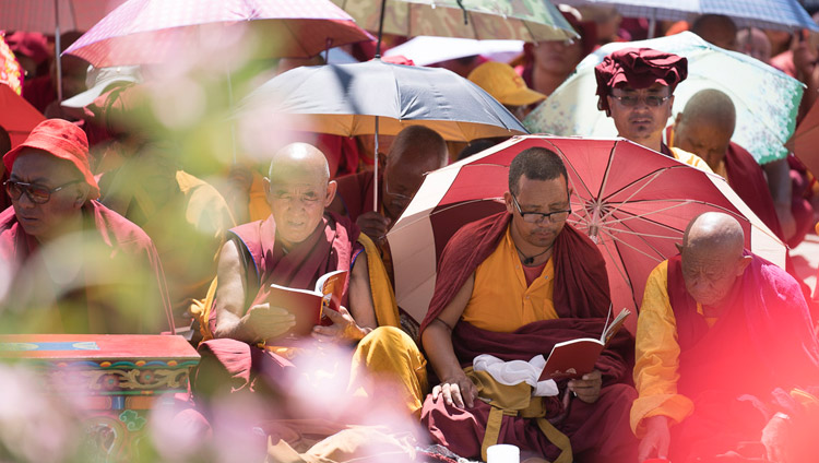 Protecting themselves from the sun with umbrellas, monks in the crowd following the text as His Holiness the Dalai Lama reads from 'A Guide to the Bodhisattva's Way of Life" on the first day of his teachings in Leh, Ladakh, J&K, India on July 28, 2017. Photo by Tenzin Choejor/OHHDL